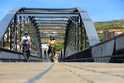 cyclists crossing the douro at the Peso a Regua bridge