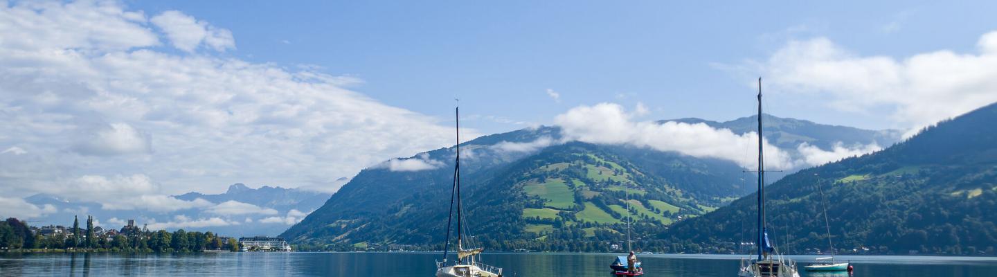 Sailing boats in lake Zell with mountains in the back