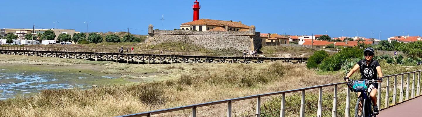 Cyclist in front of a lighthouse