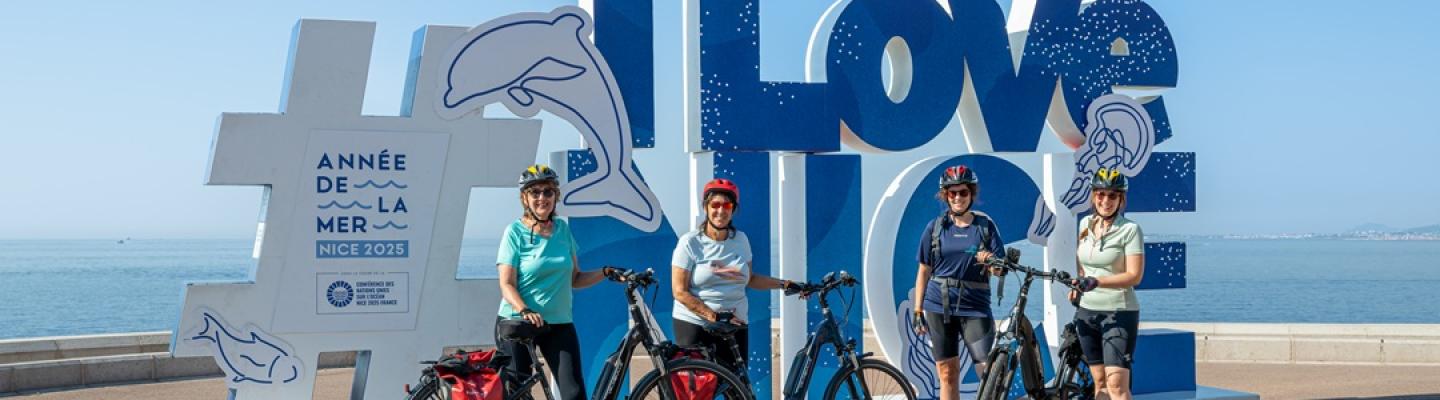 Bike group in front of Nice-Sign