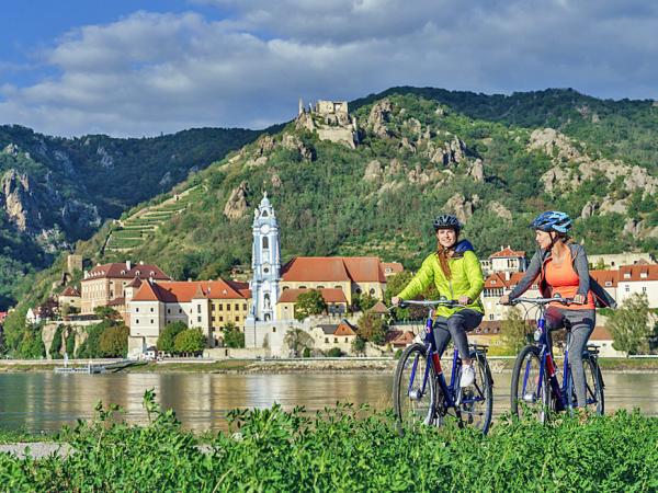 Cyclists opposite the historical village of Drnstein