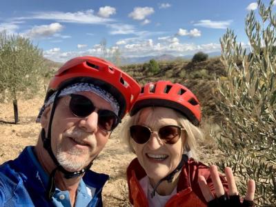 Smiling cyclists with olive trees around