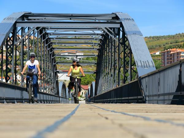 cyclists crossing the douro at the Peso a Regua bridge