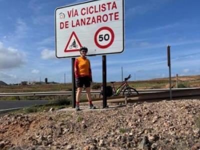 Cyclist standing in front of a traffic sign