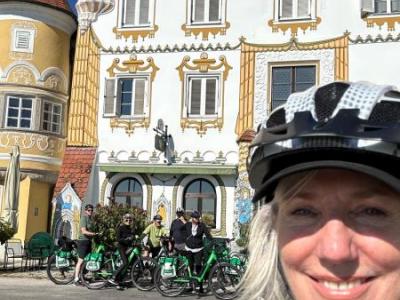 Smiling cyclists in front of a gorgeaus building