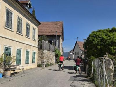 Cyclists passing typical Austrian houses in the Wachau Valley